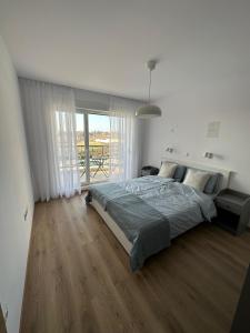 a bedroom with a bed and a large window at Cosy apartments with sea view in complex PANORAMA in Chernomorets