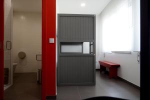 une porte dans une pièce avec un mur rouge dans l'établissement Lab Hostel Nazare, à Nazaré