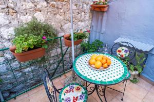 a table with a bowl of oranges on a balcony at Tulip Old Town in Dubrovnik