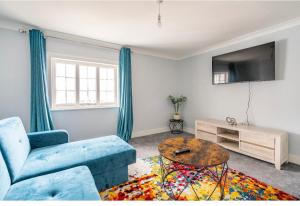 a living room with a blue couch and a table at Romney Home in Maidstone