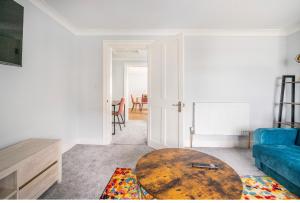 a living room with a blue couch and a table at Romney Home in Maidstone