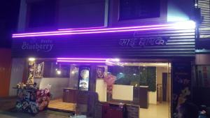 uma luz roxa na frente de uma loja em Blueberry Budget Hotel em Shirdi
