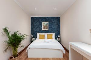 um quarto com uma cama branca e almofadas amarelas em Kensington Nest Serviced House em Londres