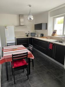uma cozinha com uma mesa e cadeiras e um lavatório em ZER GOCHOA em Cambo-les-Bains