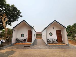 two houses with chairs and a table in the courtyard at Bunrapee House in Nan