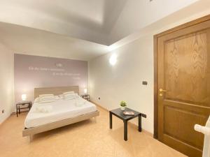 a bedroom with a bed and a wooden door at Maison Soleil Guest House Gallipoli in Gallipoli