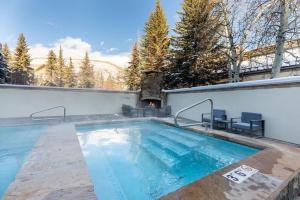 a swimming pool with a fireplace in a backyard at Villa Cortina 130 in Vail Village in Vail