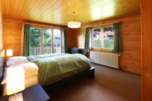 a bedroom with a bed in a wooden room at Chalet les Mayens in Saas-Fee