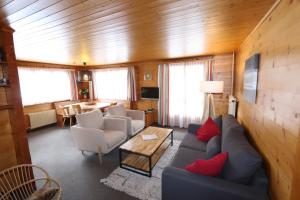 a living room with a couch and chairs and a table at Chalet les Mayens in Saas-Fee