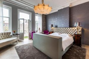 ein Schlafzimmer mit einem großen Bett und einem Kronleuchter in der Unterkunft Amstel Corner Hotel in Amsterdam