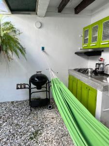 a green hammock in a kitchen with a counter at Hostal Paraiso Minca in Minca