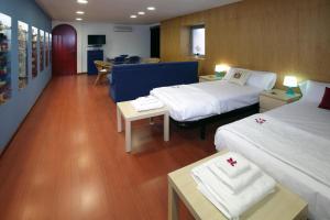 a hotel room with two beds and a table at Apartamento Granollers in Granollers