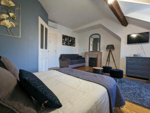 a bedroom with a bed and a living room at Logis Hotel La Tourelle du Beffroi in Bourbon-Lancy