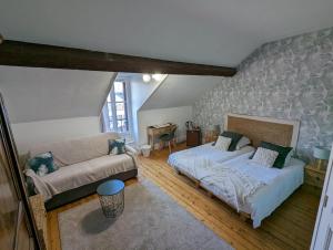 a living room with a bed and a couch at Logis Hotel La Tourelle du Beffroi in Bourbon-Lancy