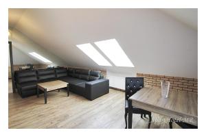 a waiting room with black leather furniture and a table at Apartamenty Piła in Piła