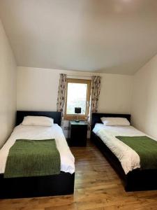 1 dormitorio con 2 camas y ventana en Ballyhoura Forest Home, en Ballyorgan