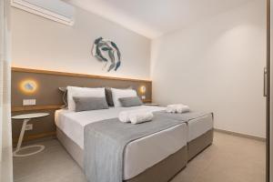 um quarto com uma cama grande e toalhas em Stylish Rhodes Apartment with Prime Location - L & C City Escape in Ilha de Rhodes