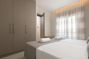 een slaapkamer met twee bedden en een groot raam bij Stylish Rhodes Apartment with Prime Location - L & C City Escape in Rhodos-stad