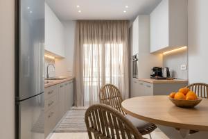 een keuken met een tafel met een kom sinaasappels erop bij Stylish Rhodes Apartment with Prime Location - L & C City Escape in Rhodos-stad