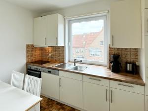 una cucina con lavandino e finestra di Ferienwohnung Buchholtz a Wittdün