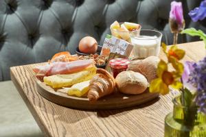 ein Tablett mit Essen auf einem Tisch mit Brot und Eiern in der Unterkunft Boutique Hotel Brasa Beemster in Middenbeemster