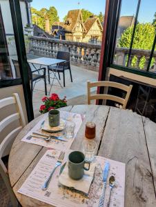a wooden table with two cups on top of it at Logis Hotel La Tourelle du Beffroi in Bourbon-Lancy