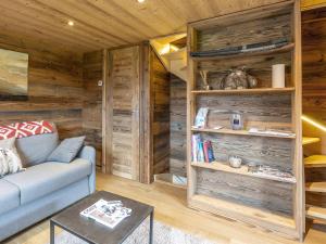 salon z drewnianymi ścianami i niebieską kanapą w obiekcie Chalet La Clusaz, 2 pièces, 4 personnes - FR-1-437-75 w mieście Clusaz