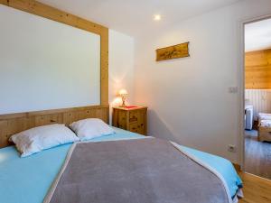 een slaapkamer met een blauw bed en een raam bij Appartement La Clusaz, 2 pièces, 4 personnes - FR-1-437-52 in La Clusaz