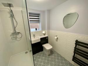 a bathroom with a toilet and a sink and a mirror at Luxury Riverside City Centre Apartment in York +19 photos
