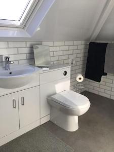 a bathroom with a white toilet and a sink at Prestatyn Loft in Prestatyn
