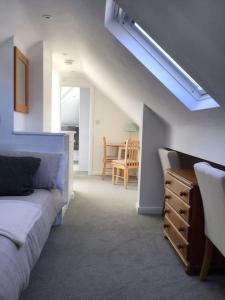 a bedroom with a bed and a dresser and a table at Prestatyn Loft in Prestatyn