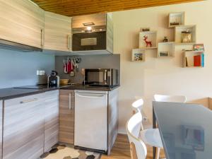 a kitchen with stainless steel cabinets and white chairs at Appartement La Clusaz, 3 pièces, 6 personnes - FR-1-437-59 in La Clusaz