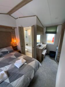 um quarto com uma cama, uma secretária e uma janela em Dee Lodge em Boat of Garten