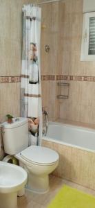 ein Badezimmer mit einem WC, einer Badewanne und einem Waschbecken in der Unterkunft Bonito bajo cerca del mar in Benicarló