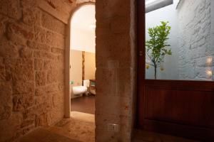 un corridoio con una porta e una pianta in vaso di Le Alcove - Luxury Hotel nei Trulli ad Alberobello