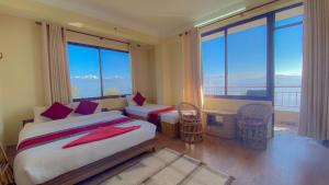 Un dormitorio con una cama grande y grandes ventanales. en Himalayan Sunrise, en Dhulikhel