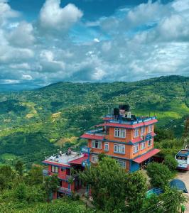 un bâtiment sur le flanc d'une colline avec un bus dans l'établissement Himalayan Sunrise, à Dhulikhel
