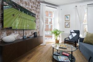 sala de estar con TV en la pared en Kensington Nest Serviced Town House en Londres