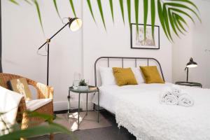 1 dormitorio con cama blanca y almohadas amarillas en Kensington Nest Serviced Town House, en Londres
