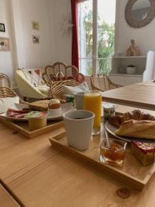 a table with a tray with bread and orange juice at Hôtel Eden - La Baigneuse in Juan-les-Pins
