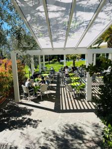 un patio con mesas bajo una pérgola en Villa Franca, en Nago-Torbole