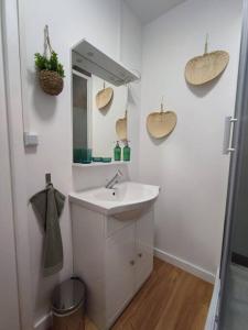 Baño blanco con lavabo y espejo en Namaste Studio by T&L, en Denain