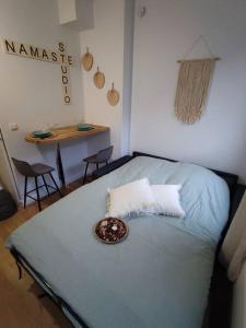 Una cama en una habitación con un tazón. en Namaste Studio by T&L, en Denain