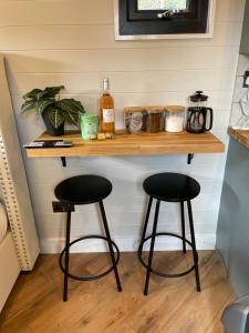 a counter with two stools in a room at Canalside View Mini Lodge with private hot tub in Llangollen