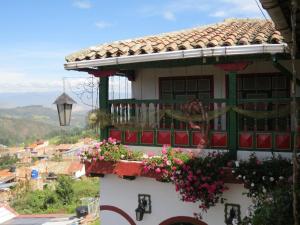 a house with a balcony with flowers on it at Hotel Portón De Ocetá in Monguí