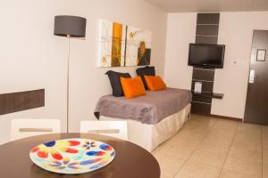 a bedroom with a bed with a table and a tv at Kube Apartments Express in Córdoba