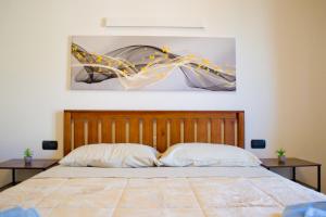een bed met twee kussens en een schilderij aan de muur bij Casa Fiume in Mantova