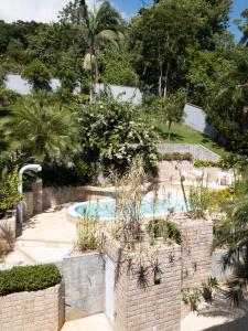 um jardim com piscina e árvores em Pousada DRIRIOS HOUSE em Jaraguá do Sul