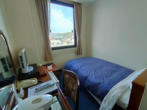 Zimmer mit einem Bett, einem Schreibtisch und einem Fenster in der Unterkunft Inuyama City Hotel in Inuyama