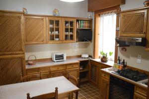 una cocina con armarios de madera y una mesa. en Asteria Venetian Suite, en Venecia